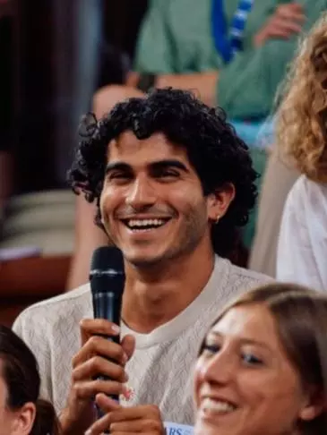Photo of Justin Hadad holding a microphone in a crowd