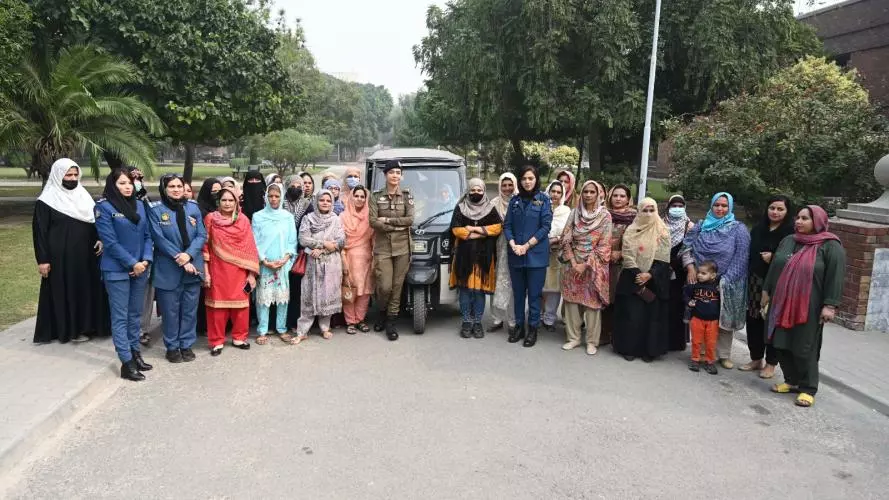 Photograph of group of women gathered by a rickshaw for training in Lahore, Pakistan