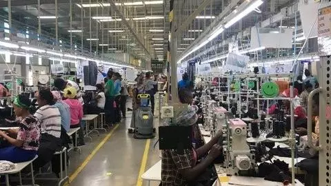 People work sewing closely together in a factory