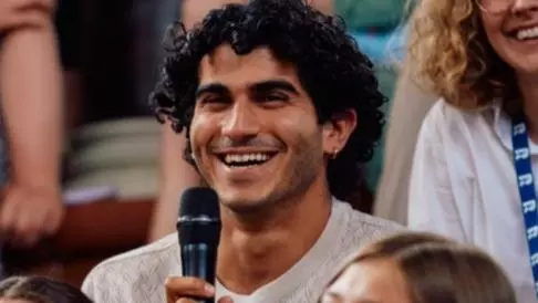 Photo of Justin Hadad holding a microphone in a crowd