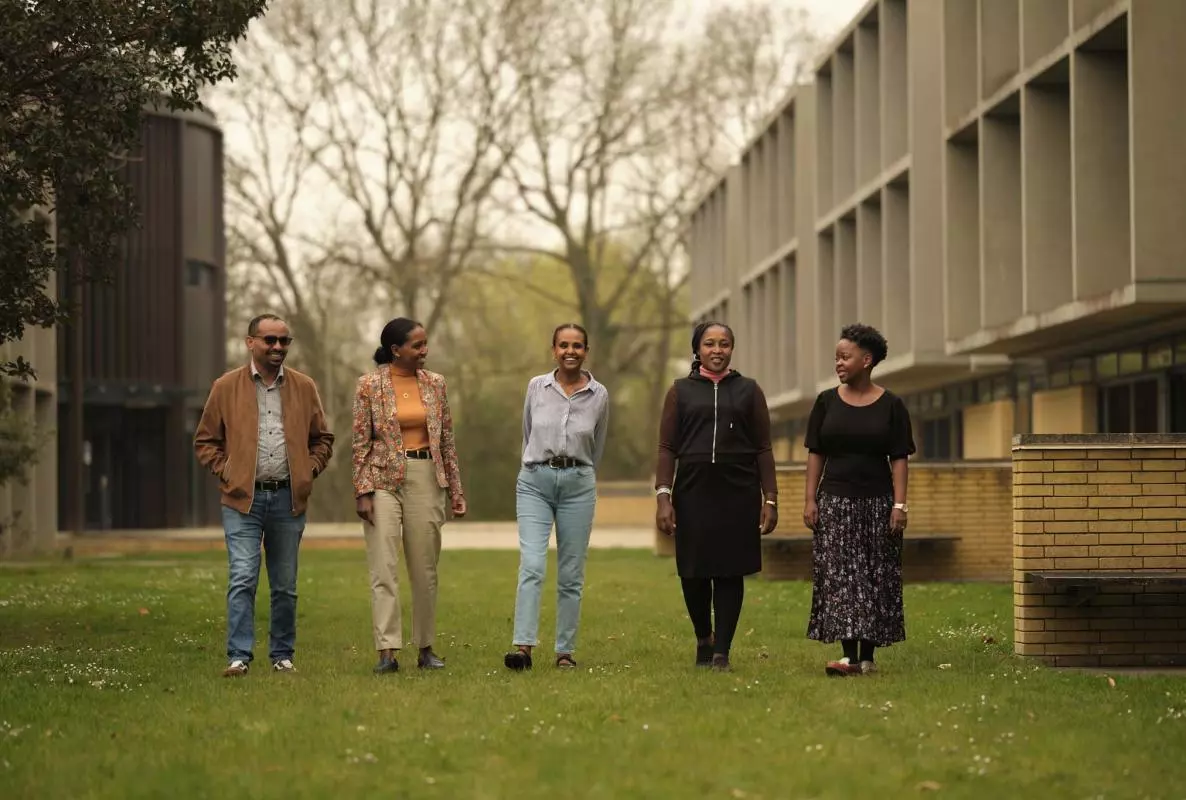 photograph of 2025 CSAE visiting fellows walking on the grass
