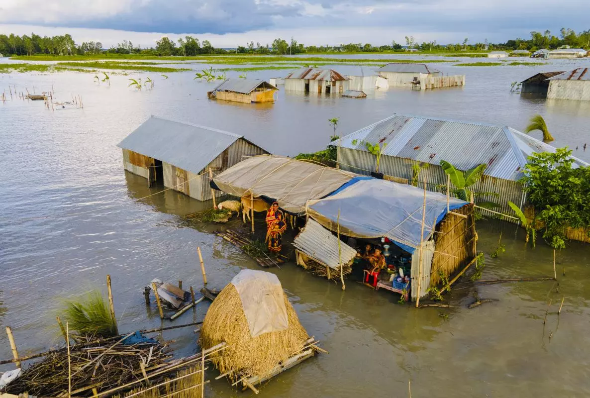 Image of houses stranded in flood water with people inside