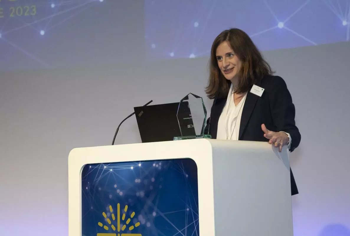 Photograph of Kate Orkin accepting the ESRC Outstanding Public Policy Impact Prize in November 2023
