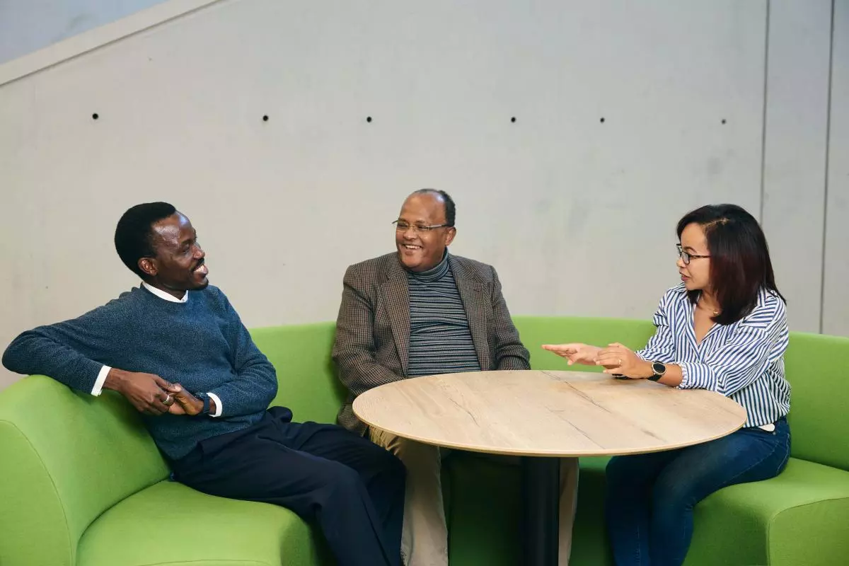 Photo of three CSAE Visiting Fellows sitting down on chairs