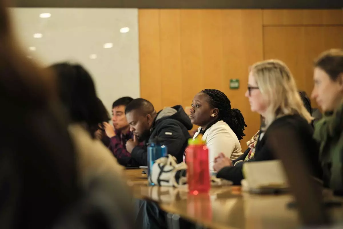 People sit listening to a presentation at tables 